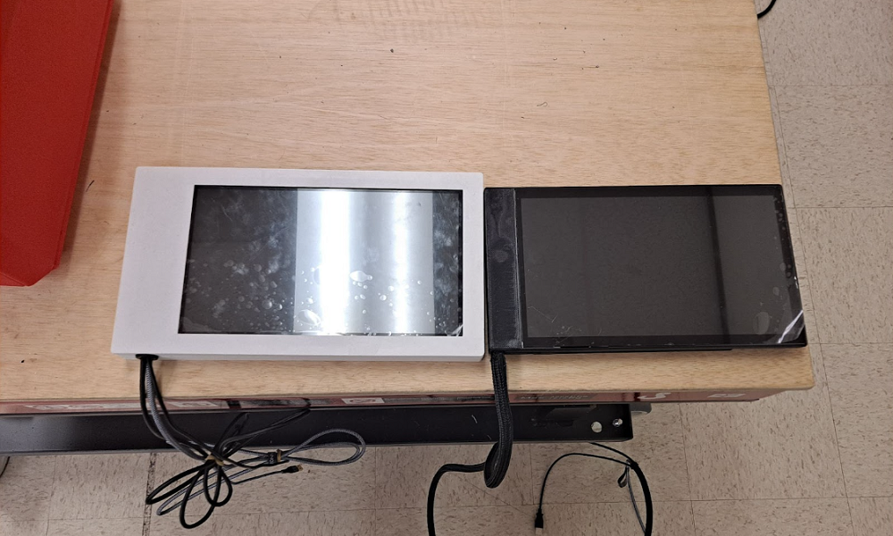 two touchscreen cases side by side. the white case is longer and wider than the black case