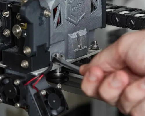 Image of a hand tightening a screw on a 3D printer print head